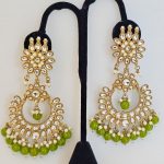 Lushkara Gold-Toned Kundan Jhumka Earrings with Green Bead Accents